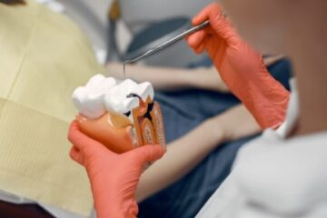 Patient with exposed tooth root and gum recession receiving dental care